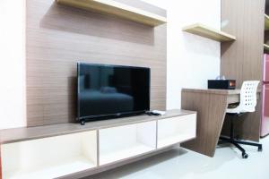 a living room with a tv on a wall at New Studio The Oasis Apartment By Travelio in Cikarang