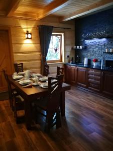 une salle à manger avec une table et des chaises et une cuisine dans l'établissement Domek u Kubusia, à Białka Tatrzańska