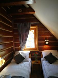 a attic room with two beds and a window at Domek u Kubusia in Białka Tatrzańska
