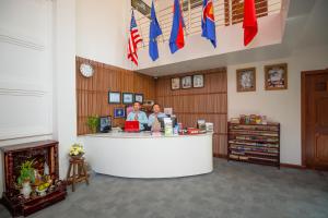 dos mujeres parados en un mostrador en una tienda con banderas en Neth Socheata Hotel, en Siem Reap