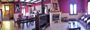 sala de estar con TV y comedor en Casa Rural La Alcazaba, en El Robledo