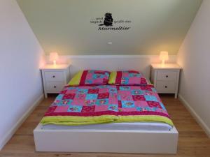 ein Schlafzimmer mit einem Bett mit zwei Nachttischen und zwei Lampen in der Unterkunft Ferienhaus Pusteblume in Garrel
