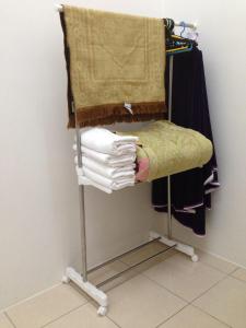 ein Handtuchhalter mit einem Haufen Klamotten drauf. in der Unterkunft NUHA HOMESTAY in Seri Iskandar