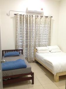 um quarto com 2 camas individuais e uma janela em NUHA HOMESTAY em Seri Iskandar