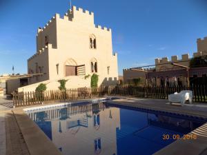 un edificio con piscina frente a un edificio en Casa Rural La Alcazaba, en El Robledo