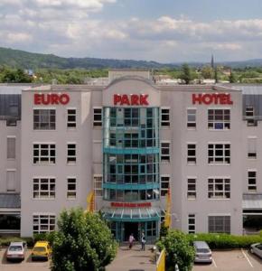 un grand bâtiment blanc avec un hôtel-parc dans l'établissement Euro Park Hotel Hennef, à Hennef