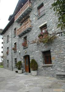 un edificio de piedra con ventanas y balcones. en Apartamentos Casa Buisan en Broto