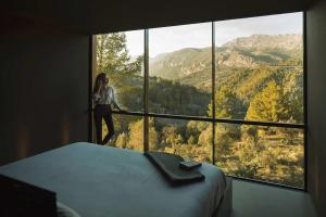 a woman is looking out a window at the mountains at VIVOOD Landscape Hotel & Spa - Designed for Adults in Benimantell