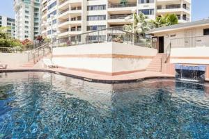 a large pool of water in front of a building at Cairns Apartment Esplanade Ocean Views in Cairns