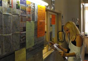 a woman is looking at her cell phone at Season Hostel 2 in Budapest