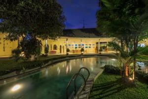 a swimming pool in front of a building at Villa Costa Sanur in Sanur