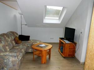 een woonkamer met een bank en een tv bij Ferienwohnung Bäumner in Bad Berleburg