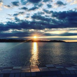 um pôr-do-sol sobre uma grande massa de água em Guest House Kamakura Zen-ji em Kamakura