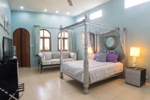 a bedroom with a canopy bed and a mirror at Villa Costa Plenty in Sanur