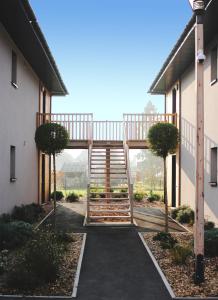 una pasarela que conduce a un edificio con una escalera de madera en Clos de la Couturelle, en Millonfosse