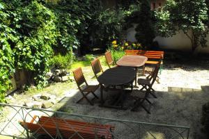 a wooden table and chairs and a wooden bench at Season Hostel 2 in Budapest