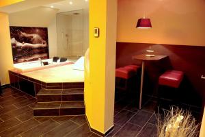 a bathroom with a tub and a sink and a table at Wellness-Keller in Bautzen