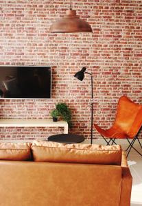 sala de estar con sofá y pared de ladrillo en Clos de la Couturelle, en Millonfosse