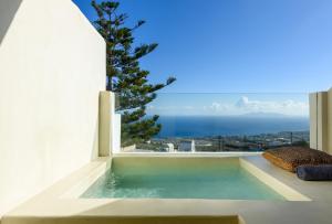 a swimming pool with a view of the ocean from a house at Divelia East in Imerovigli