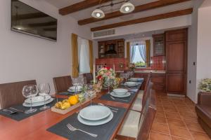 ein Esszimmer mit einem Tisch mit Tellern und Weingläsern in der Unterkunft Villa Primorje in Biograd na Moru