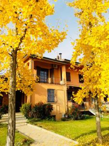 une maison avec des arbres jaunes devant elle dans l'établissement B&B Mo Va Là, à Budrio