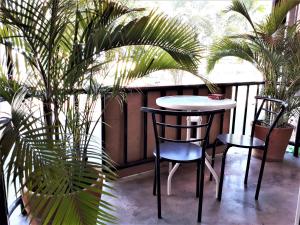 a table and two chairs on a balcony with plants at Red Samed Party House in Ko Samed