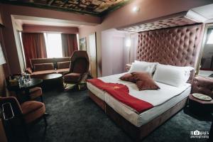 ein Hotelzimmer mit einem großen Bett und einem Stuhl in der Unterkunft Diplomat Plaza Hotel & Resort in Lukovit