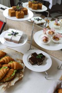 une table garnie de assiettes de desserts et de pâtisseries dans l'établissement Europa Hotel, à Irkoutsk