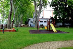 un parque con un parque infantil con un tobogán en el césped en BF Hotel, en Balatonföldvár