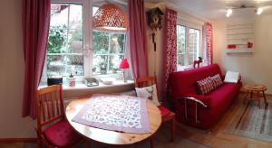 a living room with a table and a red couch at Anjas Ferienhaus Freiburg in Freiburg im Breisgau