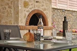 a table with a bottle of wine and bread on it at Villa Larna Corfu in Kavvadádes