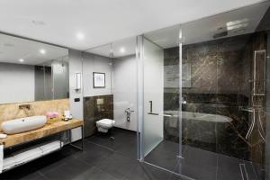 a bathroom with a shower and a sink and a toilet at InterContinental Sofia by IHG in Sofia