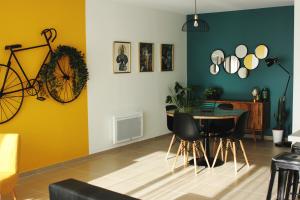 a dining room with a table and a bike on the wall at Clos de la Couturelle in Millonfosse +49 photos