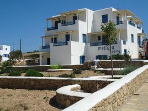 a large white building with stairs in front of it at Melissa Rooms in Koufonisia