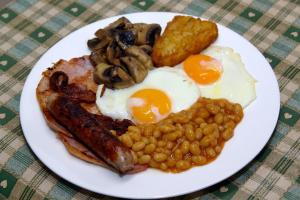 a plate of breakfast food with eggs sausage beans and mushrooms at Wortley Cottage Guest House in Wortley