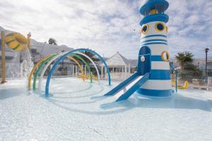 a playground with a slide and a lighthouse at Arena Beach in Corralejo