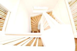 uma escada em espiral numa casa com paredes brancas em Lofts am Circus I Design & Pool em Putbus