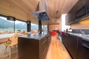 a kitchen with a large counter and a large window at Chalet Bergblick in Bramberg am Wildkogel