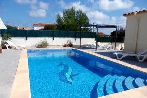 a swimming pool with blue water in a yard at MEDDAYS VILLA AMPARO in Miami Platja