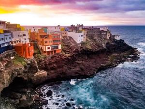 a group of buildings on a cliff near the ocean at Cliff House Gran Canaria in Gáldar