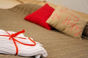 een bed met twee handdoeken en een kussen met een bedankbord bij Shauri Glamping in Noto