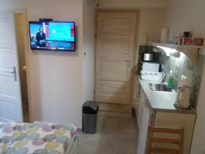eine Küche mit einem an der Wand hängenden TV in der Unterkunft Castle Base in Budapest