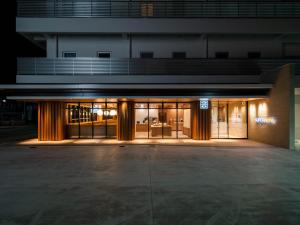 a building with a lit up facade at night at Super Hotel Yamagata Sakurambo-Higashine Station Front in Higashine