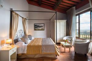 1 dormitorio con cama con dosel y silla en Leon Bianco, en San Gimignano