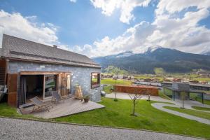 a house with a deck and mountains in the background at Chalet Bergblick in Bramberg am Wildkogel