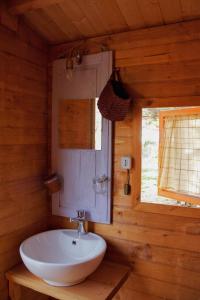 a bathroom with a sink in a log cabin at Shauri Glamping in Noto