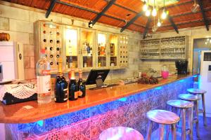 a bar with a counter with stools and bottles of wine at Tyre Boutique Apartments in Soûr