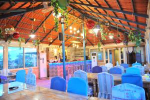 a room with blue chairs and tables and a bar at Tyre Boutique Apartments in Soûr