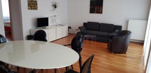 レーゲンスブルクにあるBTT Serviced Apartmentsのリビングルーム(テーブル、椅子、ソファ付)