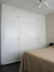 1 dormitorio con armarios blancos y 1 cama en Punta del Este frente al mar, 2 ambientes en Playa Mansa Parada 9, Edificio Paracas, en Punta del Este